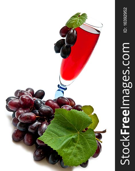 Red wine in glass with plump grapes. Isolated on white. Red wine in glass with plump grapes. Isolated on white