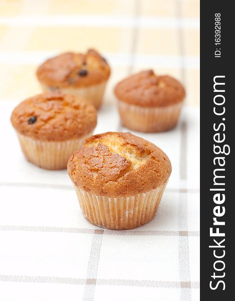 Plum-cakes on yellow chequered tablecloth. Plum-cakes on yellow chequered tablecloth