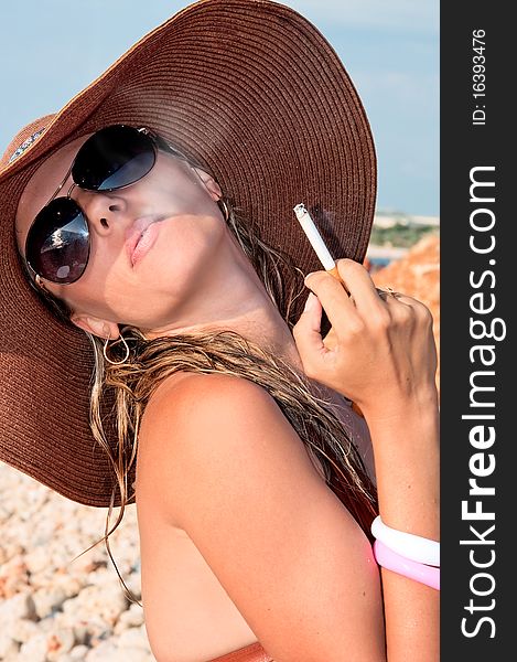 Attractive woman in a hat smoking a cigarette