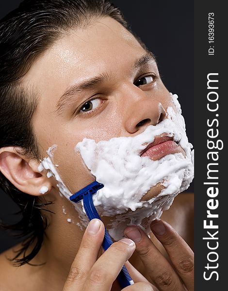 handsome young man shaving. handsome young man shaving