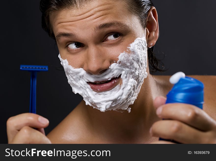 handsome young man shaving. handsome young man shaving