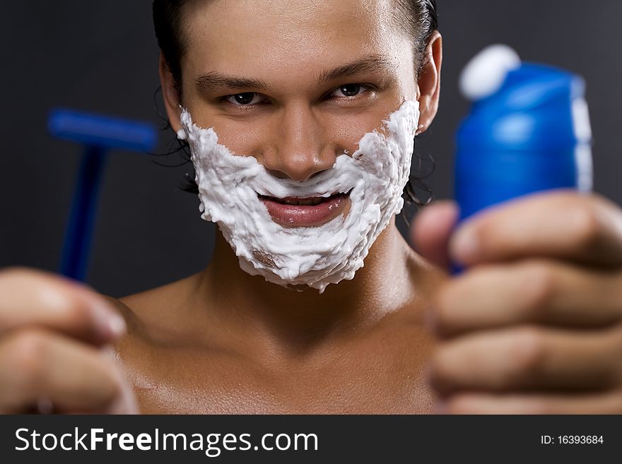 handsome young man shaving. handsome young man shaving