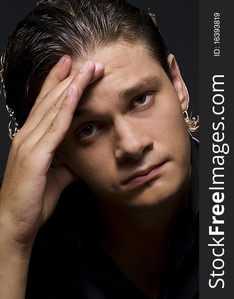 Closeup portrait of a upset young man with hand on his head