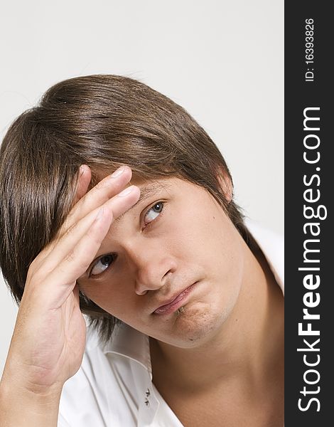 Closeup portrait of a upset young man with hand on his head