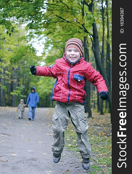 Joyful boy jumping in autumn park