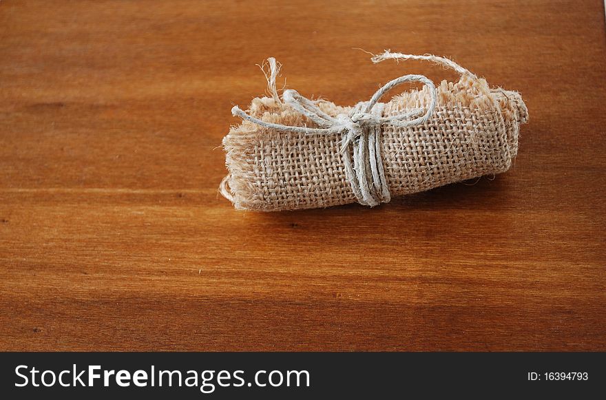 Image of little canvas bundle on wood table. Image of little canvas bundle on wood table