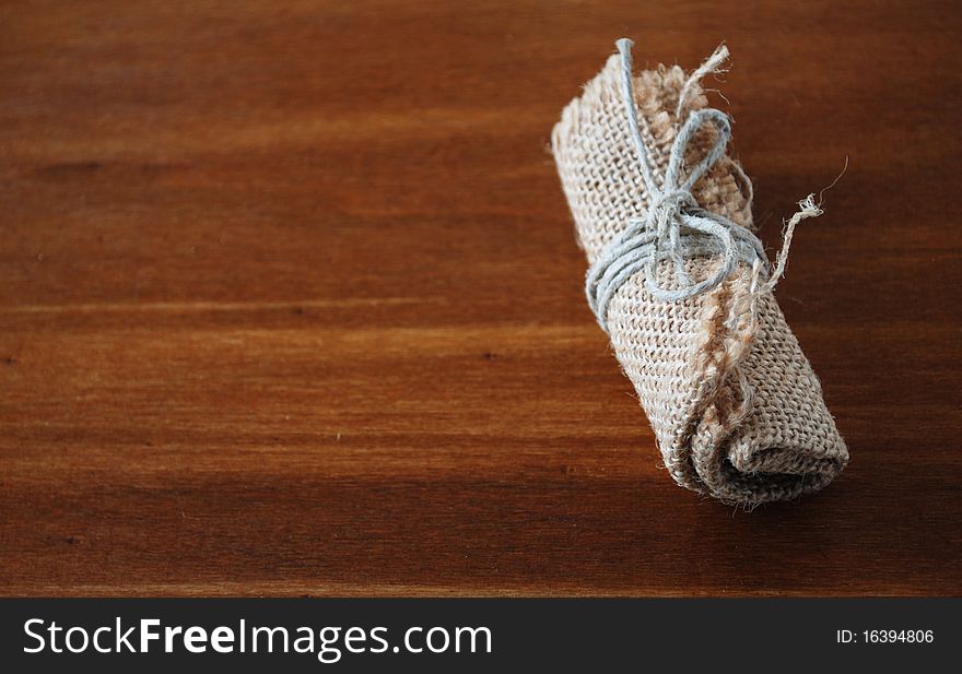 Image of little canvas bundle on wood table. Image of little canvas bundle on wood table