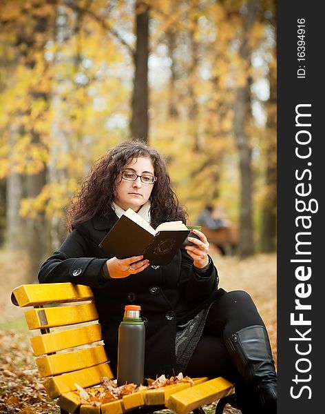 Young Woman Reading Book In Autumn Park