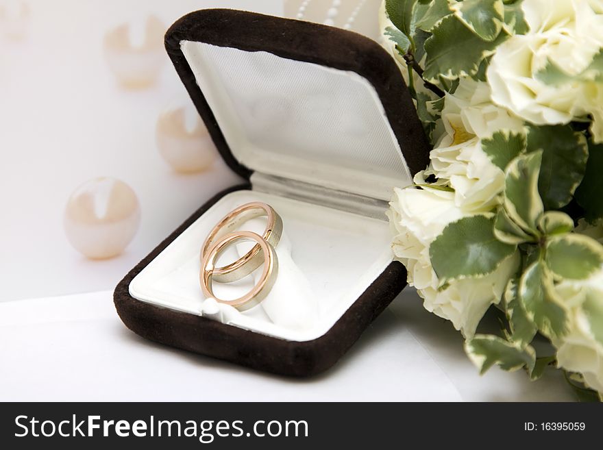 Two gold wedding rings and bouquet