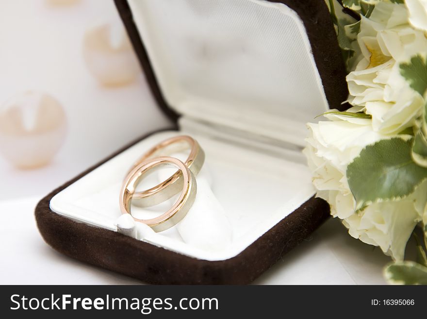 Two gold wedding rings and bouquet