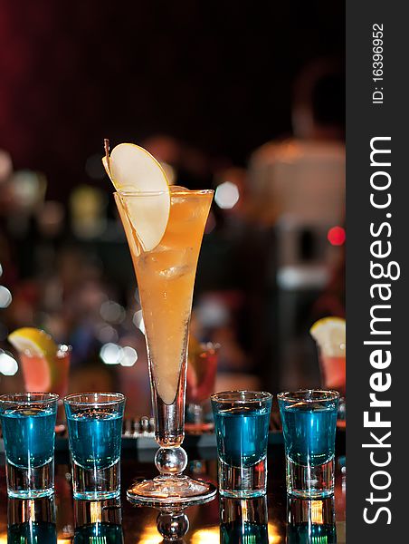 Long apple cocktail with four blue shots