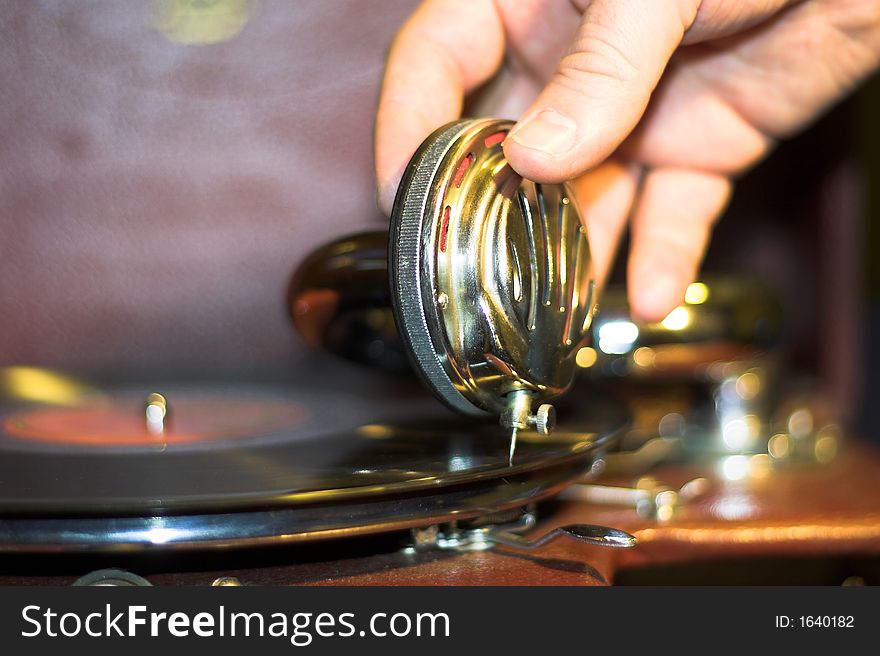 Old gramophone and human hand starting music. Old gramophone and human hand starting music