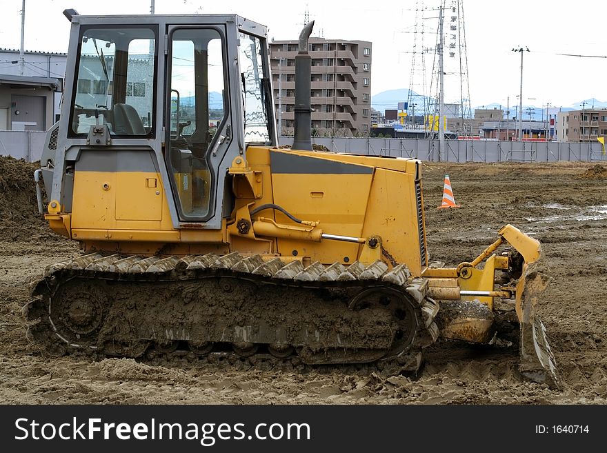 Image of a bulldozer in a construction area of a city.