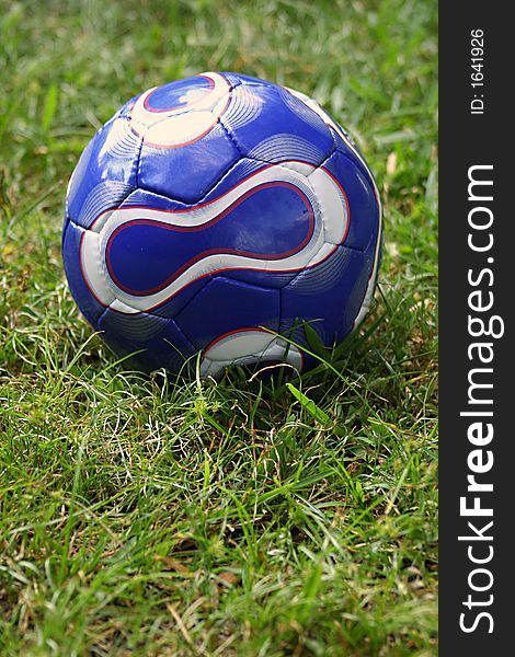 Blue soccer ball in grass outside