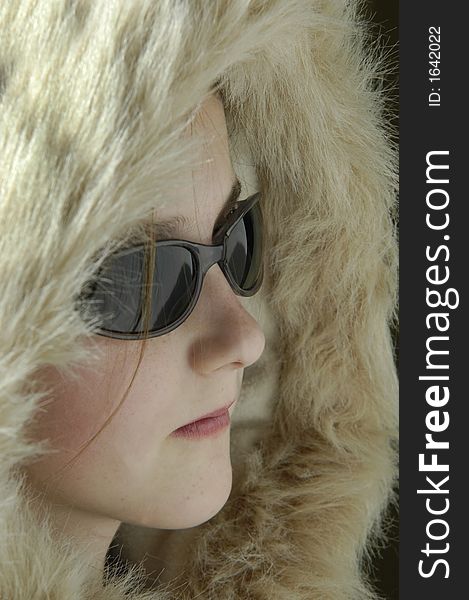 Portrait of teen girl wearing sunglasses and winter coat with fur lined hood. Portrait of teen girl wearing sunglasses and winter coat with fur lined hood