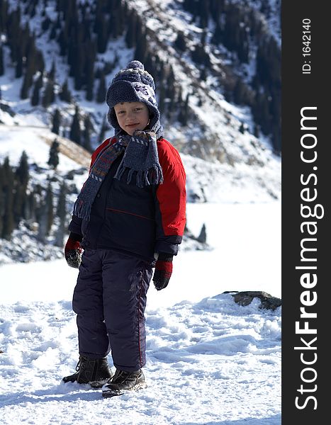 Boy and winter mountains - walk beside mountain lake