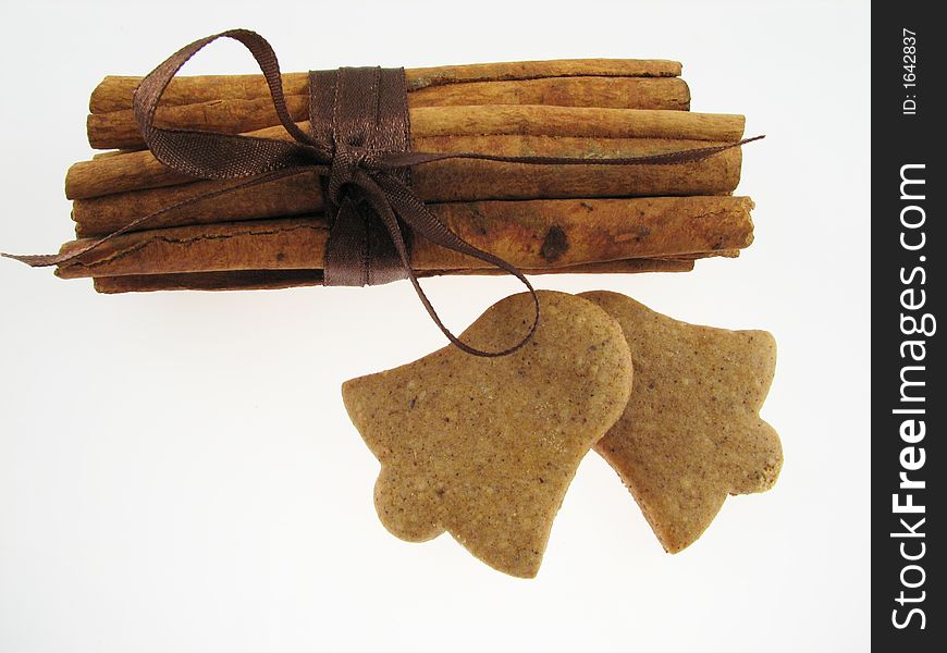 Gingerbreads in a bell shape and two sicks  of  cinnamon. Gingerbreads in a bell shape and two sicks  of  cinnamon