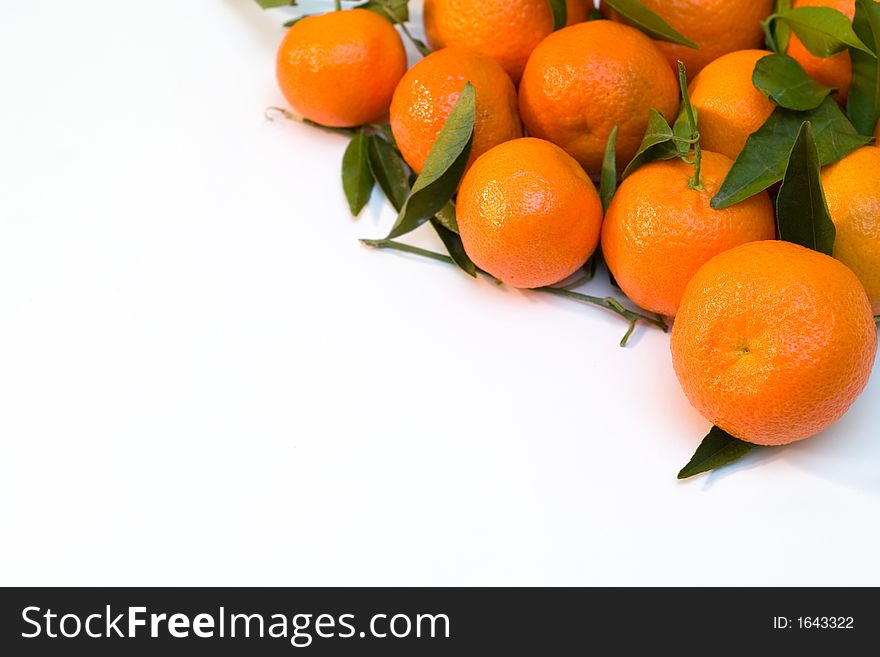 A pile of orange tangerine brancheswith green leaf on white background. A pile of orange tangerine brancheswith green leaf on white background