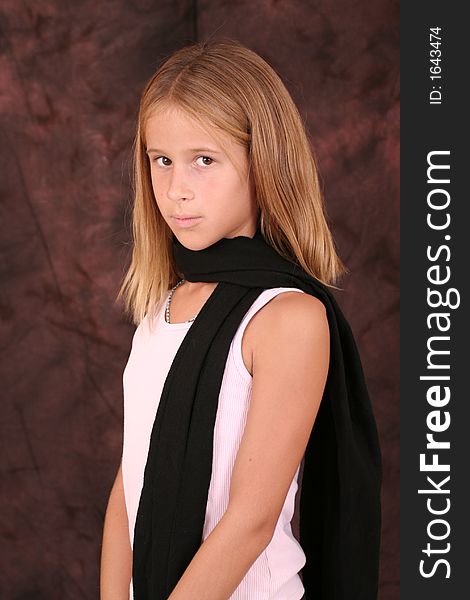 A young girl poses for photo wearing a scarf. A young girl poses for photo wearing a scarf