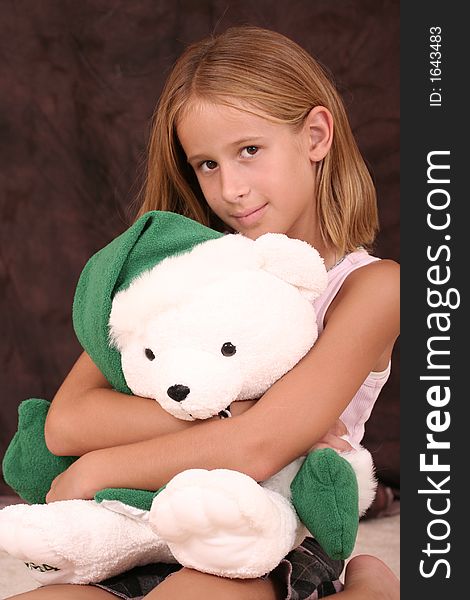 Young girl hugs a Christmas teddy bear. Young girl hugs a Christmas teddy bear