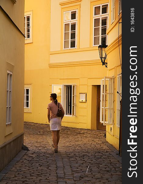 Girl walking between yellow buildings