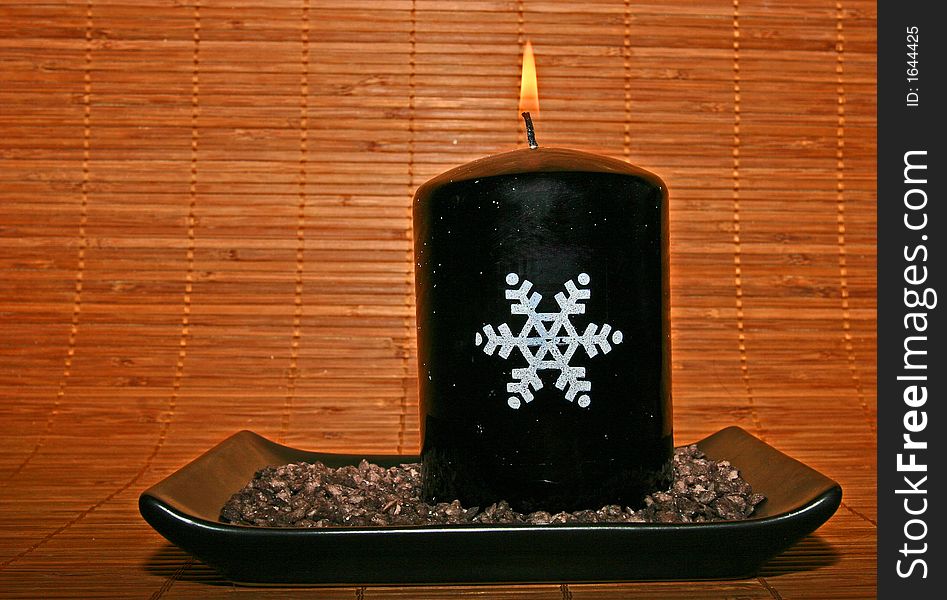 Christmas candle on a bamboo background