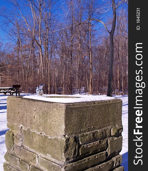 A snowy water fountain in a park during winter. A snowy water fountain in a park during winter