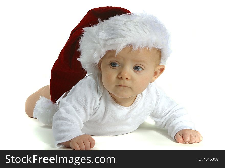 A baby wearing a Santa hat on a white background. A baby wearing a Santa hat on a white background