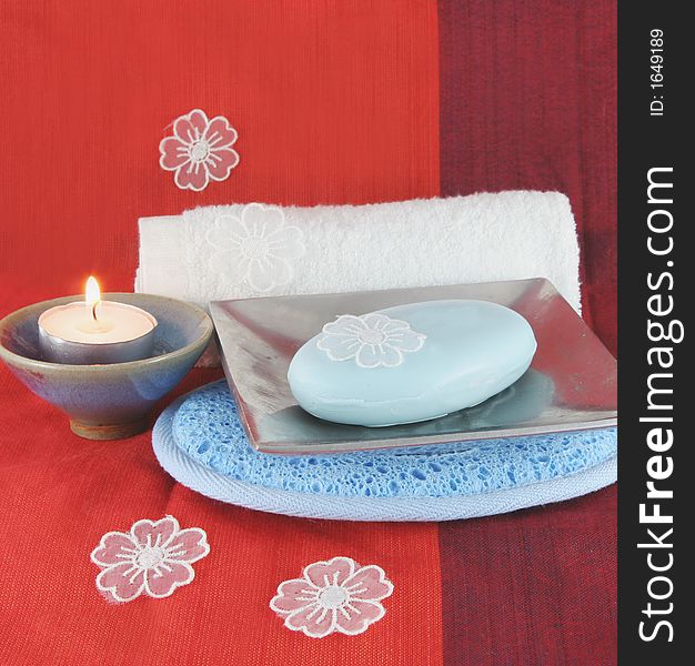 Burning candle and white flowers with soap in a dish - spa products