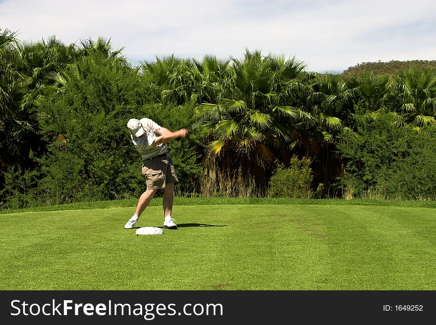Golfer hitting the ball.
