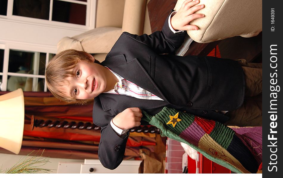 Boy holding a christmas stocking in a living room. Boy holding a christmas stocking in a living room