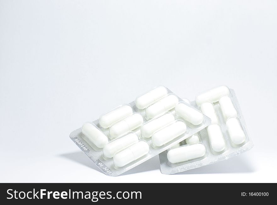 White tablets in a package lying on a white background