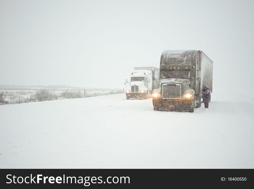 Truckers putting on chains in a fierce winter storm