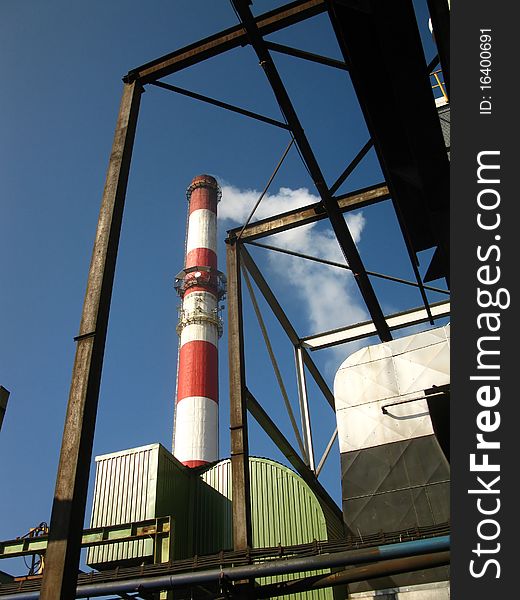 Red and white chimney with outgoing exhaust gases or steam