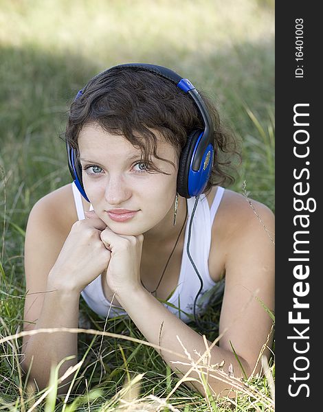 Young girl listens to music on the nature