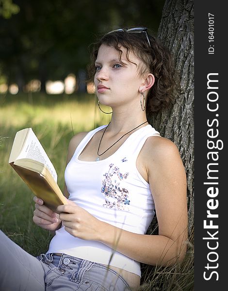 Girls reading book outdoors