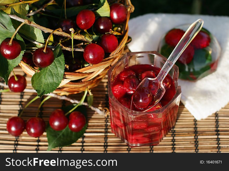 Bowl of cherry jam and some fresh fruits