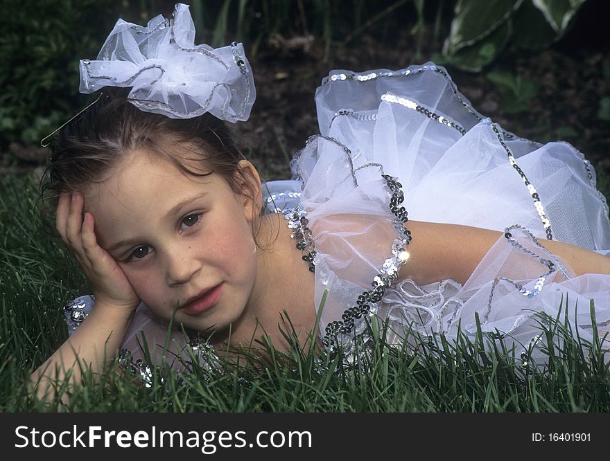 Young girl lying in grass in ballerina costume. Young girl lying in grass in ballerina costume.