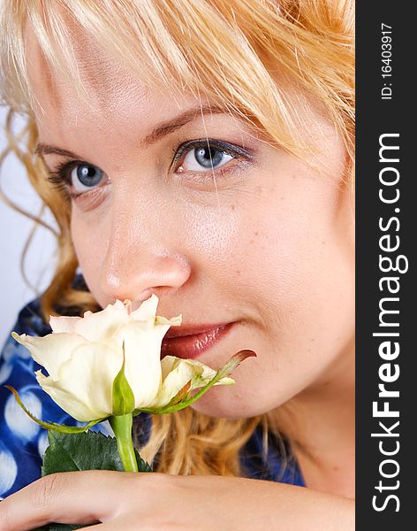 Portrait of a young and attractive blond holding a white rose.