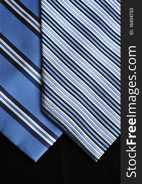 Two ties in blue tones on a black background. Two ties in blue tones on a black background.