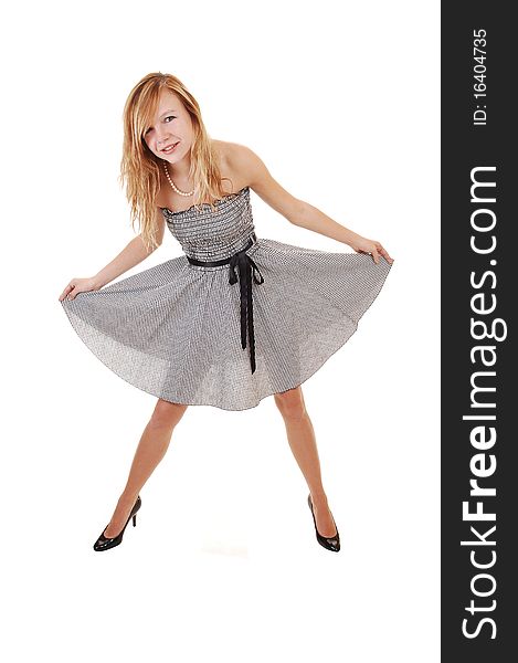 A young pretty blond woman in a black white dress and black heels, standing in the studio, shooing her nice body, over white background. A young pretty blond woman in a black white dress and black heels, standing in the studio, shooing her nice body, over white background.