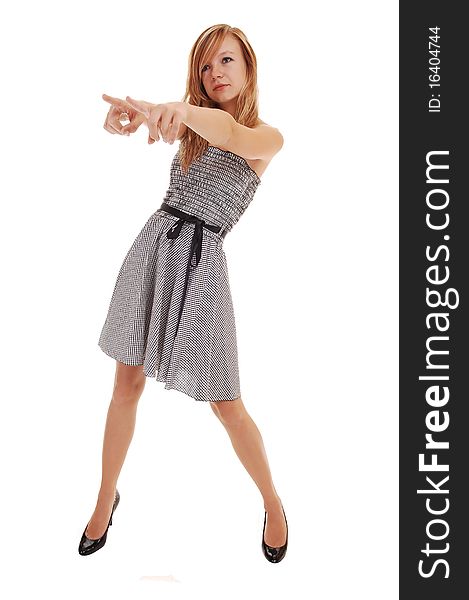 A young pretty blond woman in a black white dress and black heels, standing in the studio, pointing with her fingers, over white background. A young pretty blond woman in a black white dress and black heels, standing in the studio, pointing with her fingers, over white background.