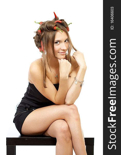 Portrait of a young woman with creative hair style with red hot chili peppers in her hair isolated on white. Portrait of a young woman with creative hair style with red hot chili peppers in her hair isolated on white