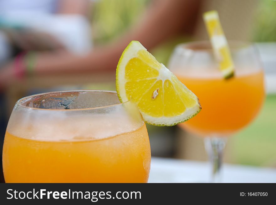 Image of a glass of orange drink with fruit