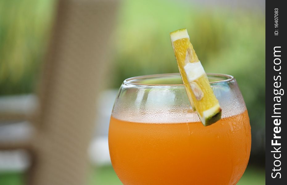 Image of a glass of orange drink with fruit