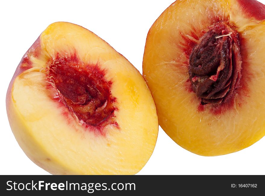 Two halves of cut yellow red-ripe peach isolated on white