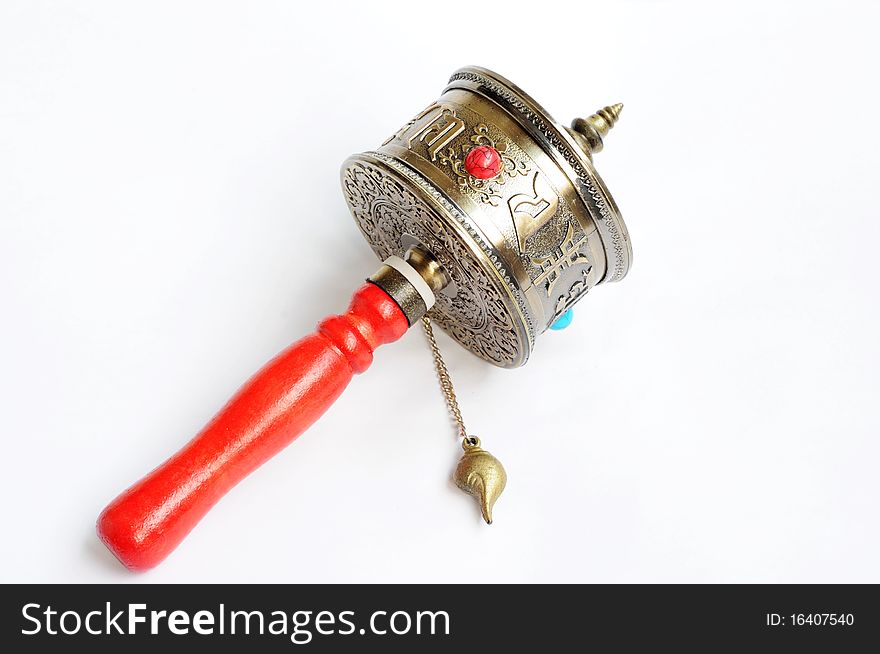 A Tibetan prayer wheel isolated on a white background.