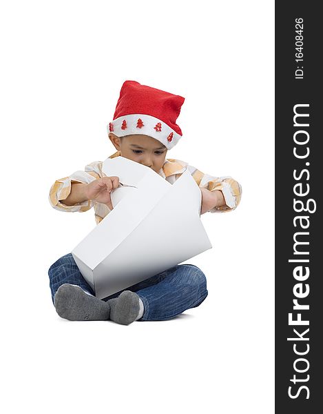 Cute boy with santa claus hat opening a gift, isolated on white background. Cute boy with santa claus hat opening a gift, isolated on white background