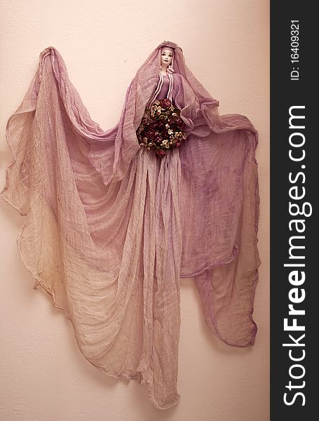 A pink decorative fairy hanging on the wall