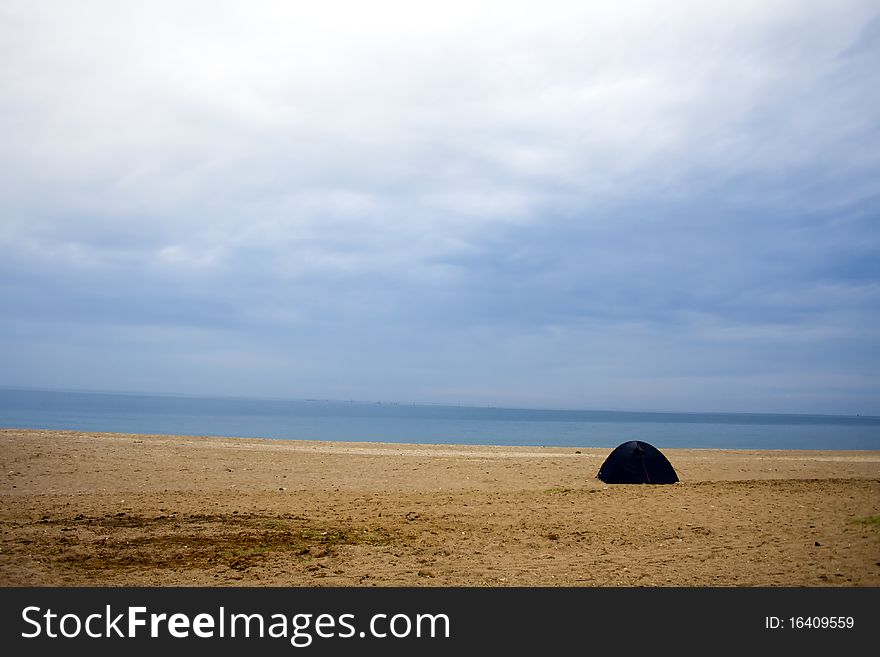 A beach scene with accumulated clouds and a tent. A beach scene with accumulated clouds and a tent
